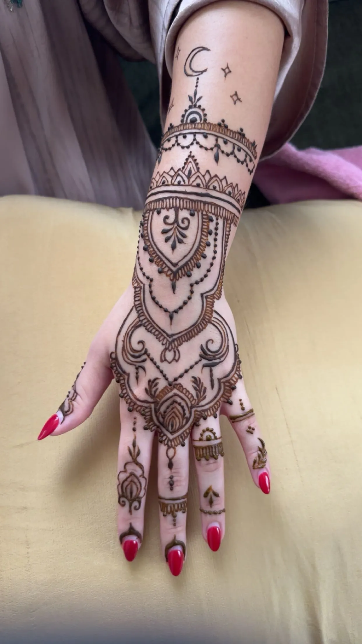 Arabic bridal henna with a crescent moon and chandelier motifs, painted in Dubai